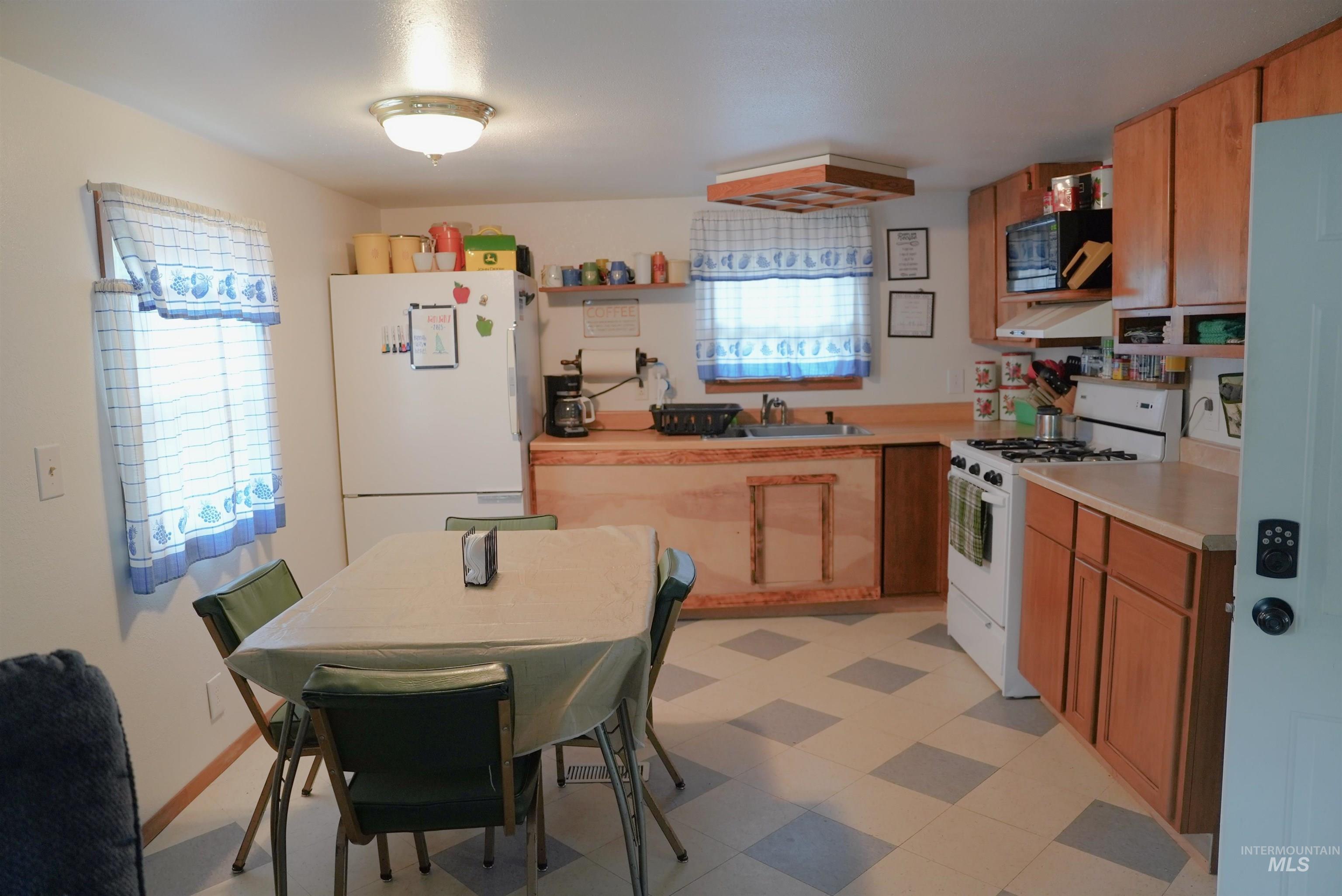 8395 Highway 21 Lowman, ID 83637 - Photo 19 of 22 Kitchen featuring white appliances, light countertops, light flooring, custom range hood, and open shelves