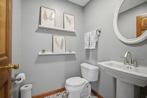 a bathroom with a toilet a sink and mirror