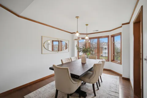 a dining room with furniture a chandelier and wooden floor