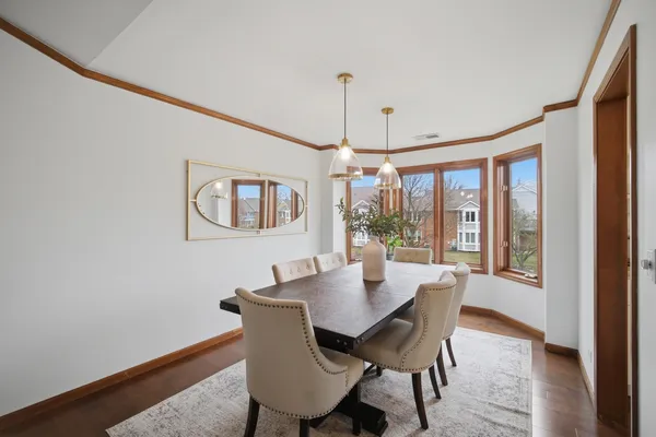 a dining room with furniture a chandelier and wooden floor