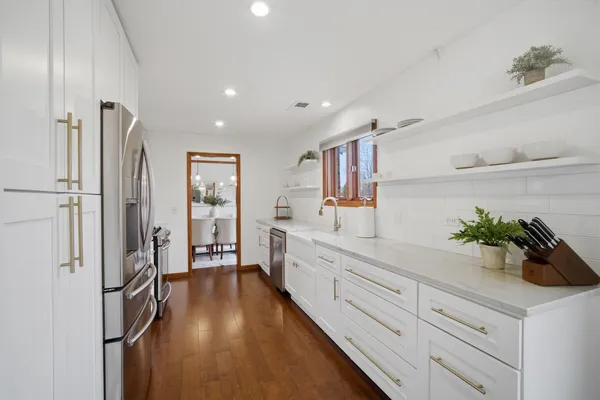 a hallway with white cabinets and wooden floor