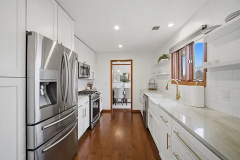 a large kitchen with stainless steel appliances sink a stove and refrigerator