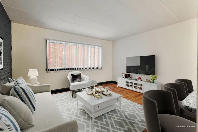 a living room with furniture a flat screen tv and a window