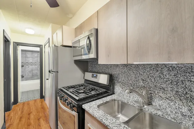 a kitchen with granite countertop a sink stove and cabinets