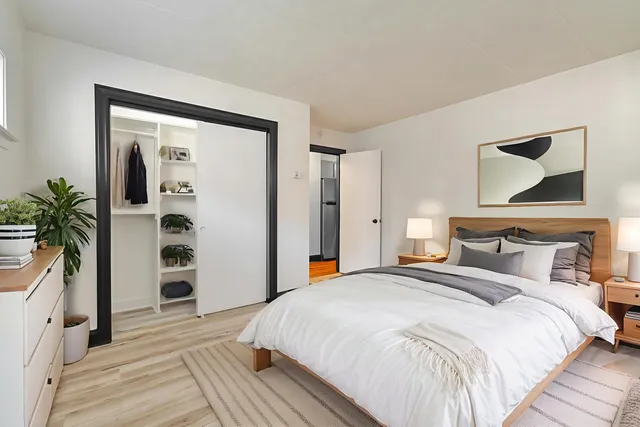 a bedroom with a large bed and a potted plant