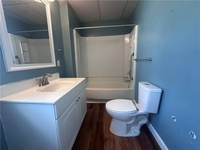 a bathroom with a granite countertop sink toilet and a mirror