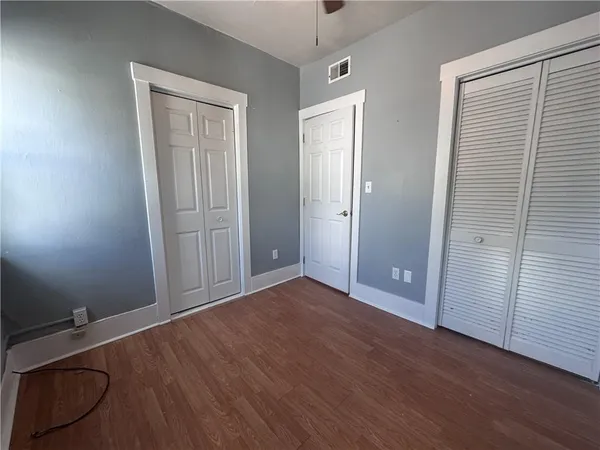 an empty room with wooden floor and closet