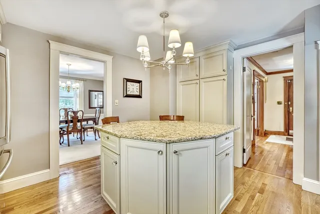 a bathroom with a granite countertop sink a mirror and a wooden floor