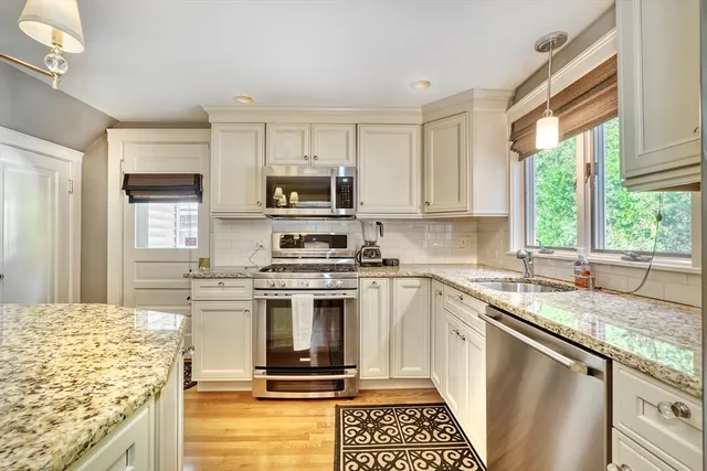 a kitchen with a stove a sink a microwave and wooden cabinets