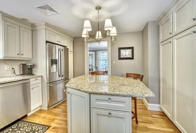 a kitchen with stainless steel appliances granite countertop a sink refrigerator and cabinets