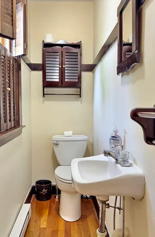 a bathroom with a toilet a sink and mirror