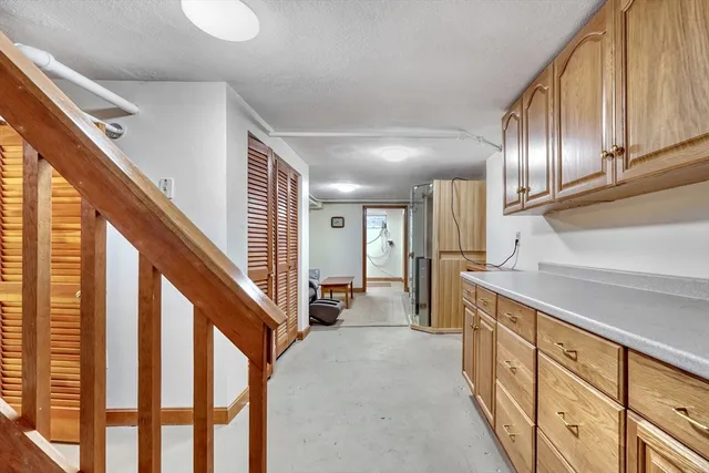 a hallway with wooden cabinets and stairs