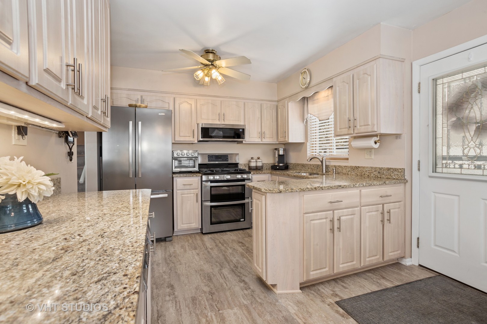 2227 South Wolf Road Des Plaines, IL 60018 - Photo 5 of 24 a kitchen with kitchen island granite countertop a stove a sink and a refrigerator