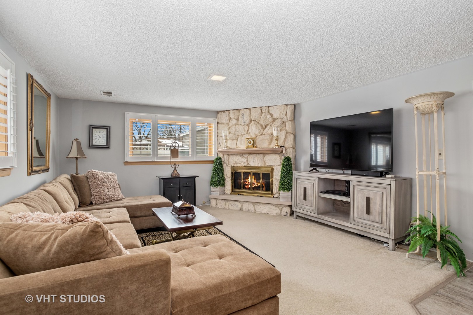 2227 South Wolf Road Des Plaines, IL 60018 - Photo 7 of 24 a living room with furniture a flat screen tv and a fireplace
