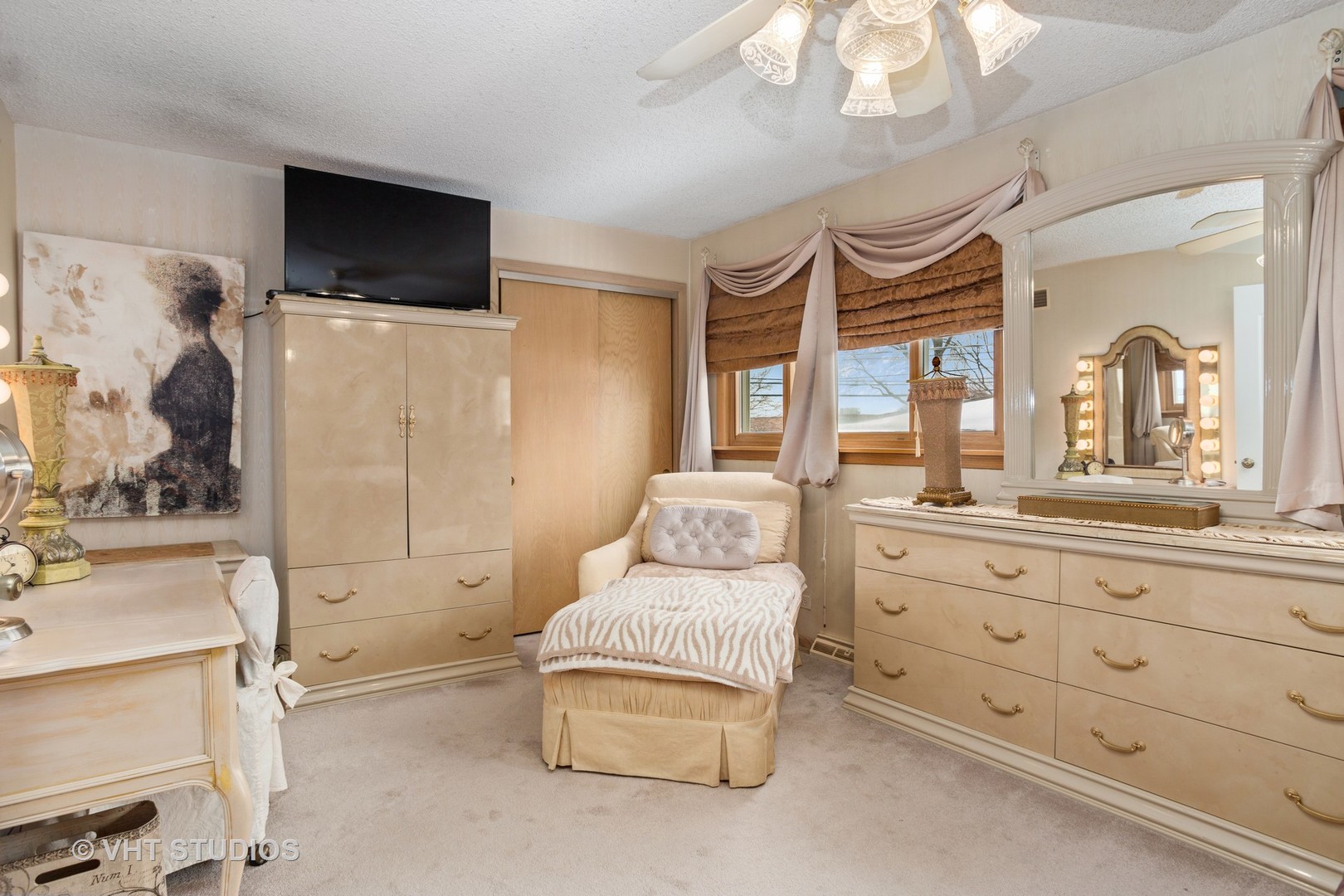 2227 South Wolf Road Des Plaines, IL 60018 - Photo 9 of 24 a spacious bedroom with a bed a mirror and a flat tv screen on dresser