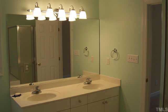 3806 Whispering Branch Road Raleigh, NC 27613 - Photo 7 of 9 a bathroom with a double vanity sink and mirror