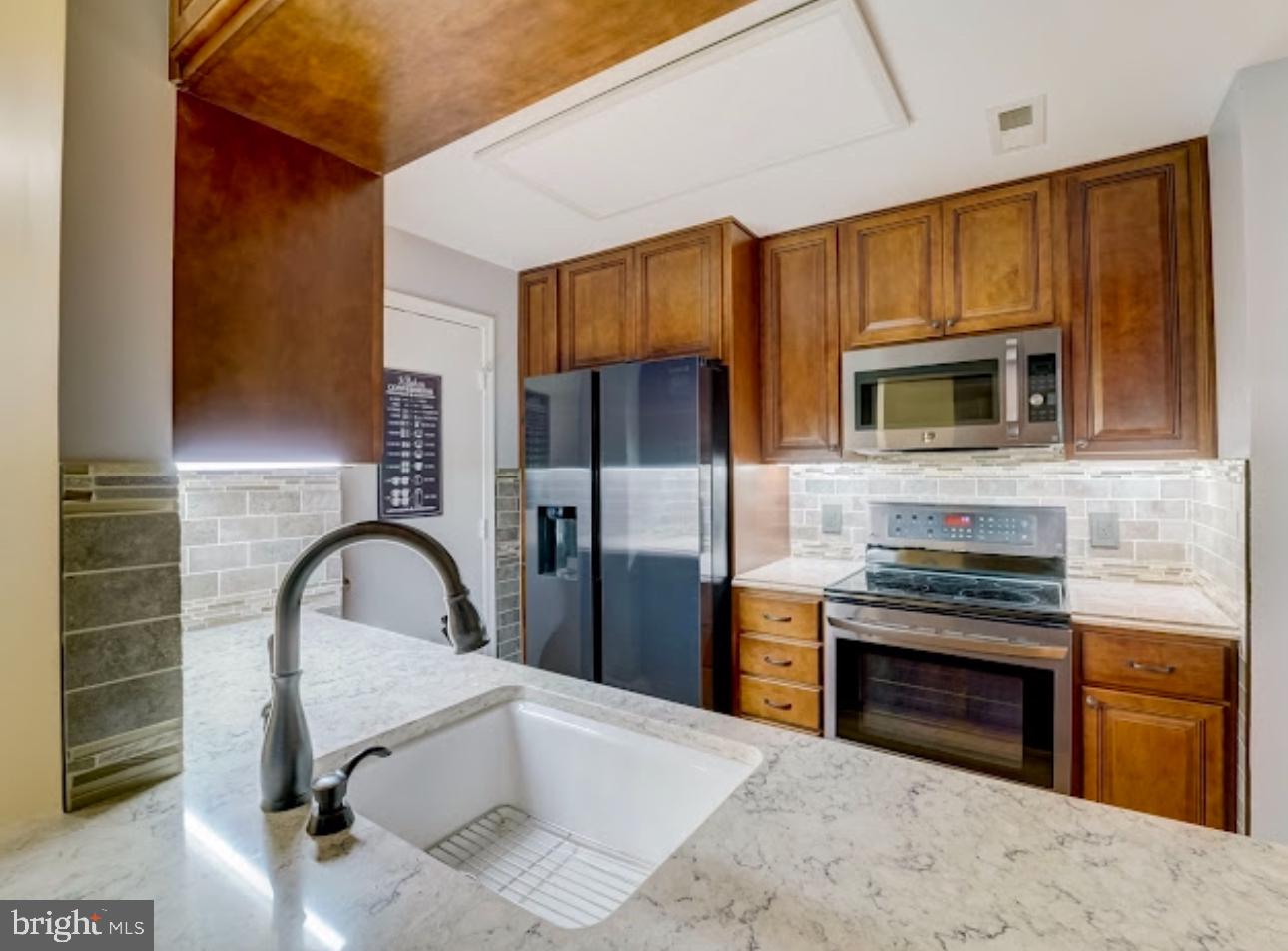3313 Sir Thomas Drive Silver Spring, MD 20904 - Photo 6 of 15 a kitchen with granite countertop a stove and a sink