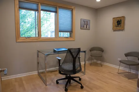 a view of a workspace with furniture and a window
