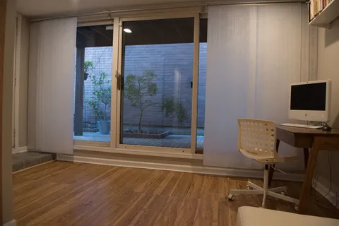 a view of a workspace with furniture and wooden floor