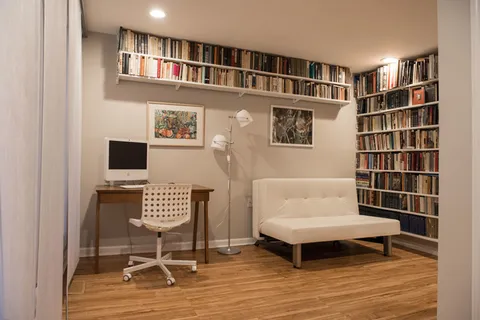 a living room with a couch and a bookshelf