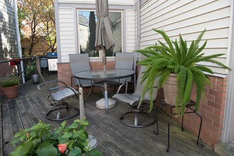 a backyard of a house with barbeque oven table and chairs