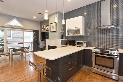 a kitchen with a stove a sink a dining table and chairs