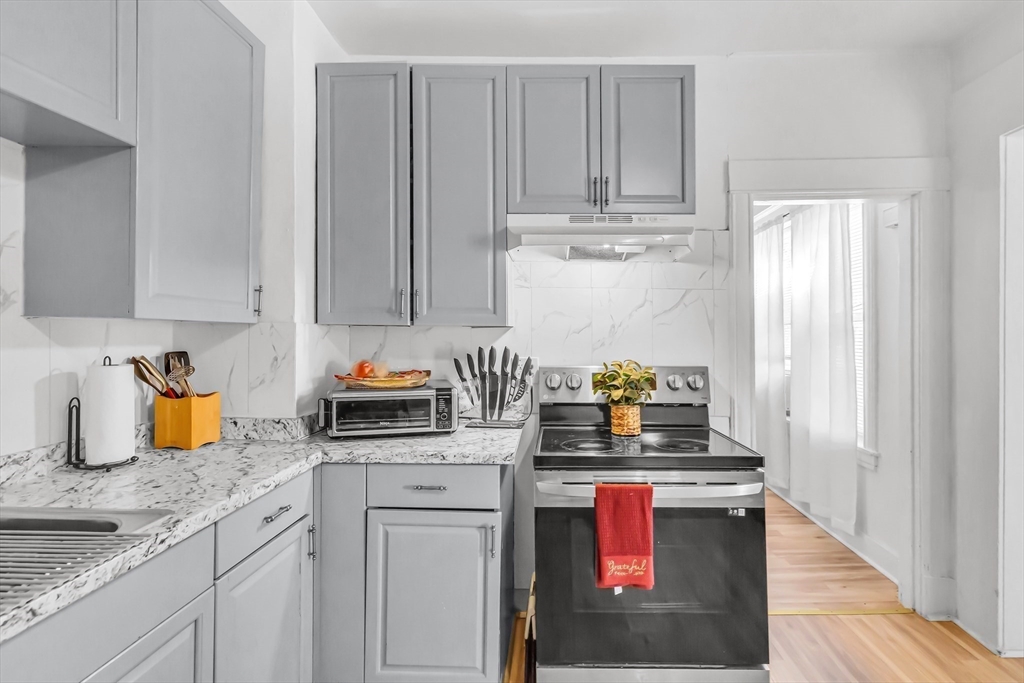 428 Page Boulevard Springfield, MA 01104 - Photo 20 of 40 a kitchen with stainless steel appliances granite countertop a stove a sink and a white cabinets