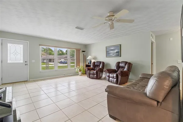 a kitchen with stainless steel appliances granite countertop a dining table chairs microwave and sink