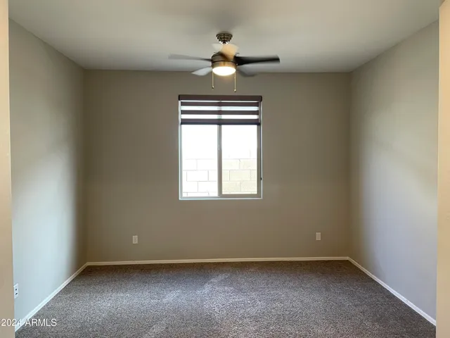 an empty room with a window and a fan