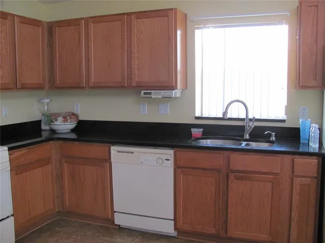 a kitchen with stainless steel appliances granite countertop a sink a stove and cabinets