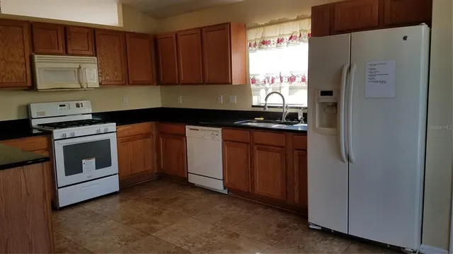 a kitchen with stainless steel appliances granite countertop a stove a refrigerator and a stove