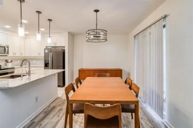 a dining room with a table chairs and a kitchen view