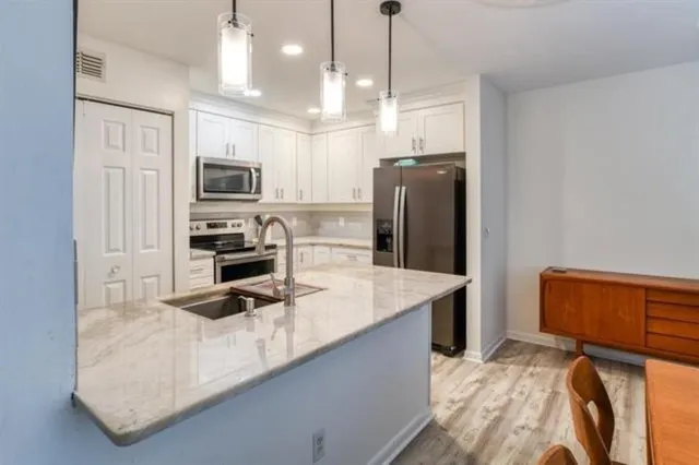 a kitchen with kitchen island a counter top space appliances and cabinets