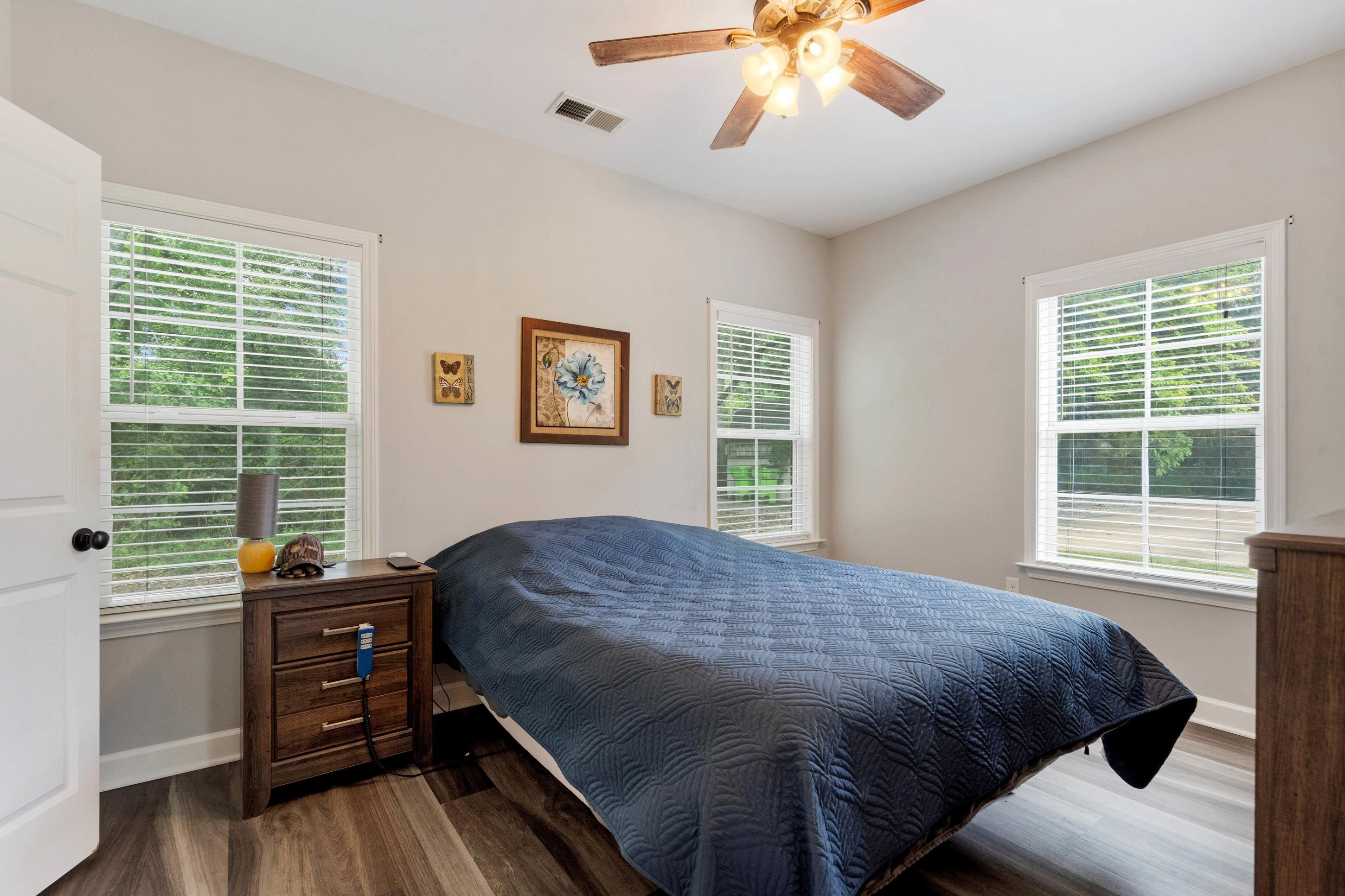 7757 Brunswick Road Millington, TN 38053 - Photo 28 of 40 Bedroom featuring wood-finish flooring, a ceiling fan with integrated lighting, and two windows with blinds