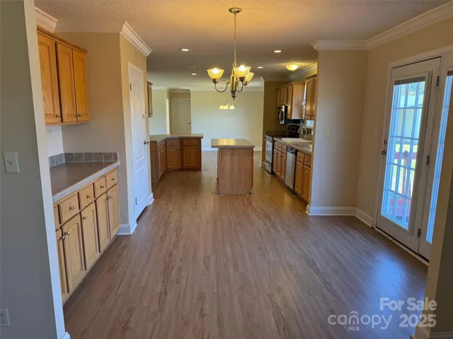a view of a hallway with wooden floor and chandelier
