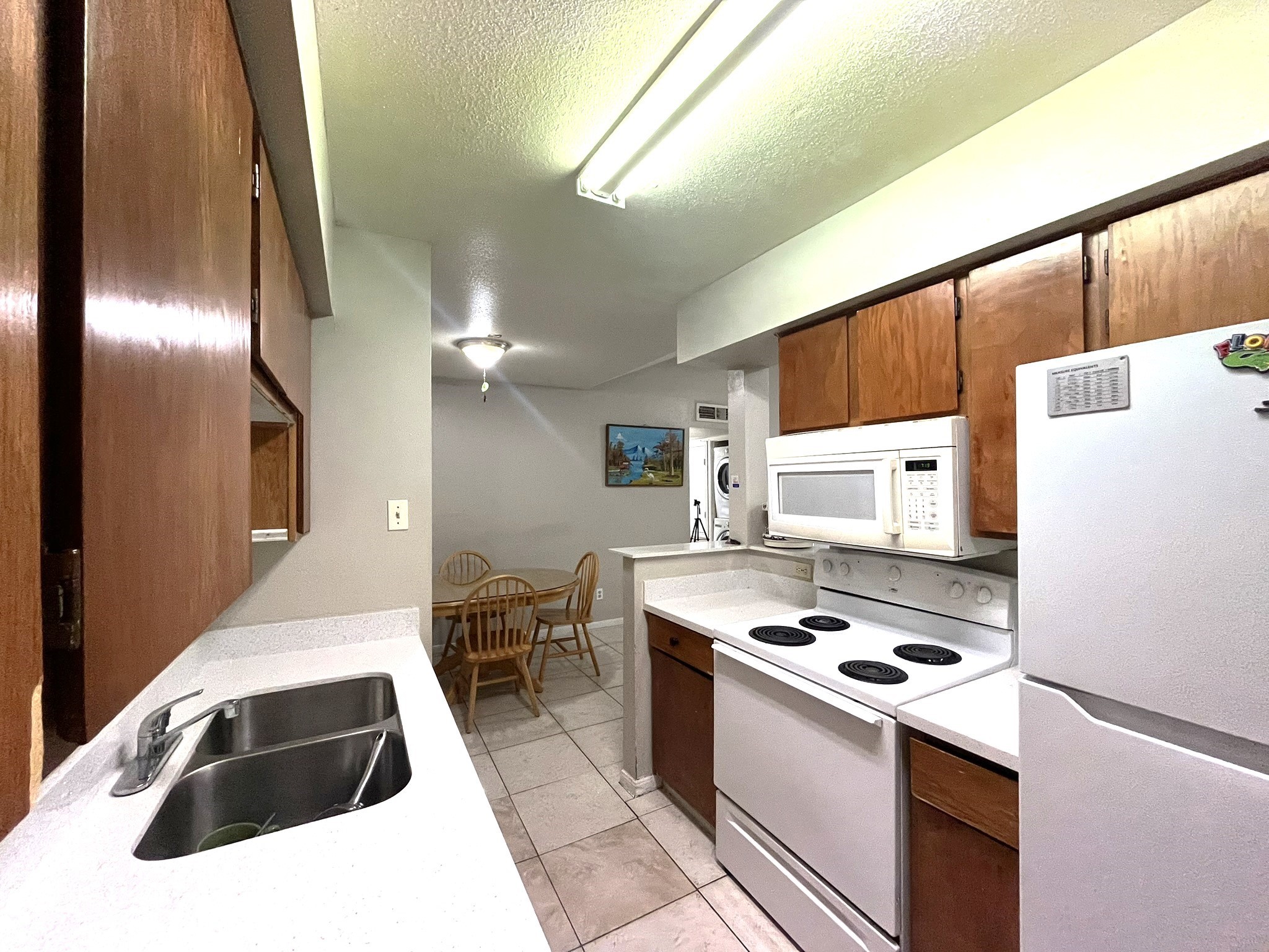 10211 Sugar Branch Drive, Unit 434 Houston, TX 77036 - Photo 7 of 13 a kitchen with kitchen island a white counter top space a stove and a refrigerator