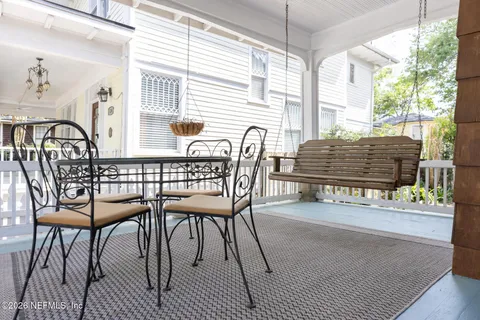a porch with a bench and a yard