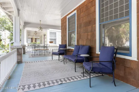 a living room with furniture and floor to ceiling windows
