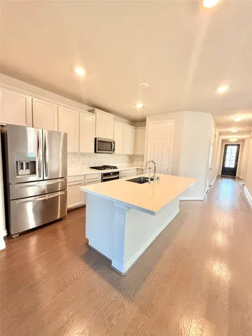 a kitchen with stainless steel appliances a refrigerator and a stove top oven