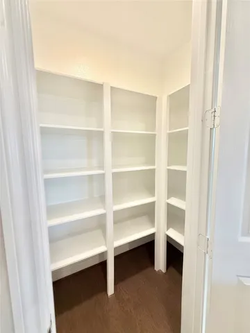a view of walk in closet with empty racks