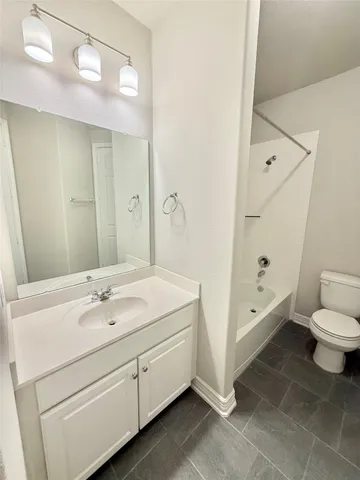 a spacious bathroom with a double vanity sink toilet and shower