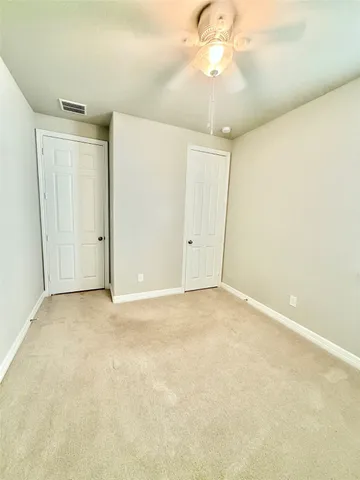 an empty room with a chandelier fan and a chandelier fan