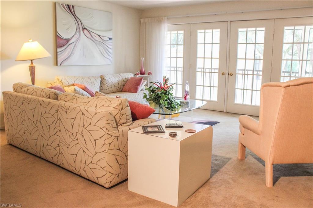 197 Albi Road, Unit 202 Naples, FL 34112 - Photo 3 of 12 a bed room with a bed and a couch