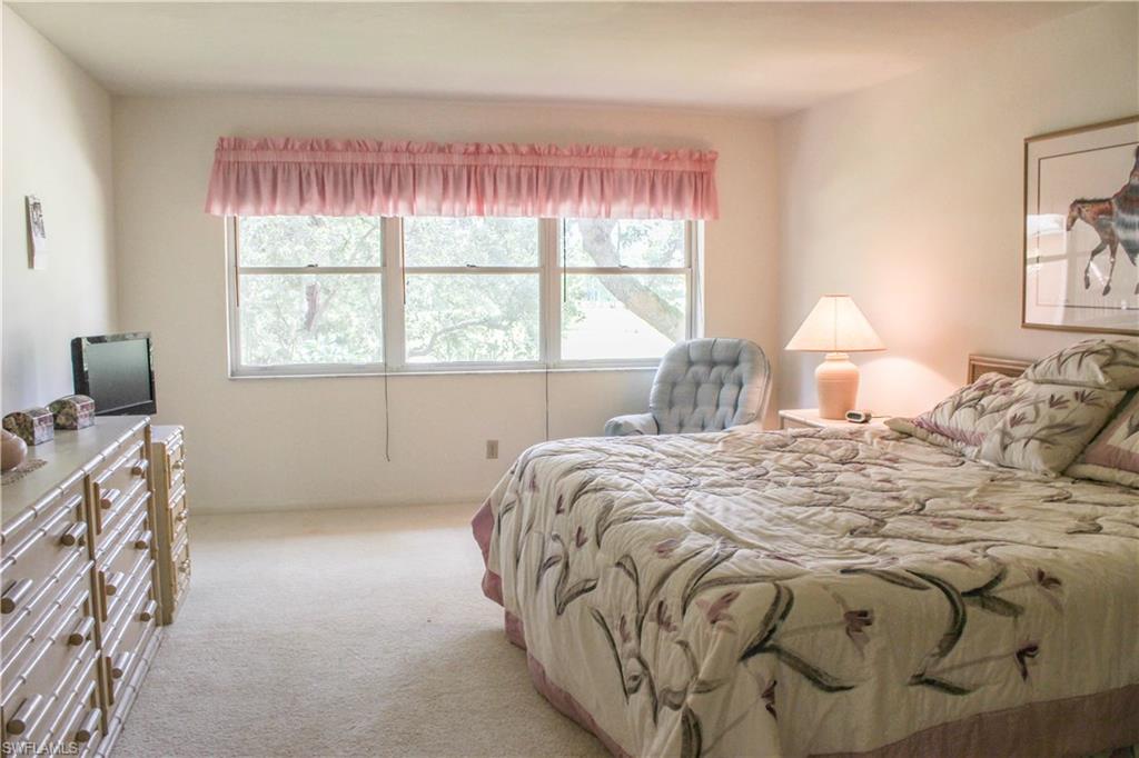 197 Albi Road, Unit 202 Naples, FL 34112 - Photo 5 of 12 a bedroom with a bed and a window