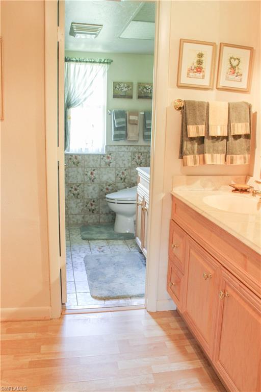 197 Albi Road, Unit 202 Naples, FL 34112 - Photo 6 of 12 a bathroom with a granite countertop sink and a mirror