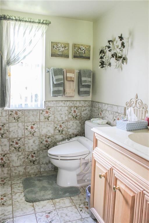 197 Albi Road, Unit 202 Naples, FL 34112 - Photo 7 of 12 a bathroom with a toilet sink and mirror
