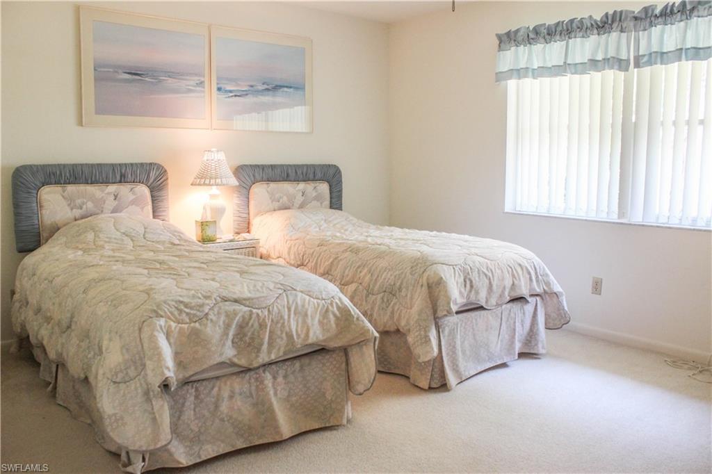 197 Albi Road, Unit 202 Naples, FL 34112 - Photo 8 of 12 a spacious bedroom with two beds and painted walls