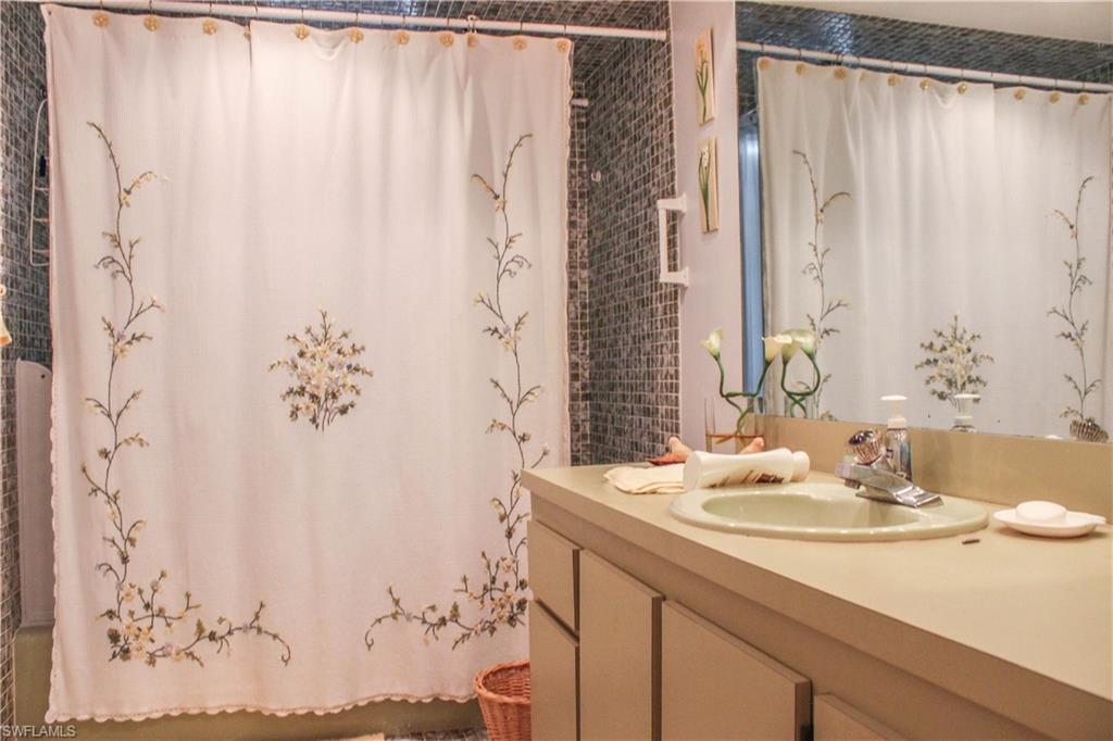 197 Albi Road, Unit 202 Naples, FL 34112 - Photo 10 of 12 a bathroom with a sink and a mirror