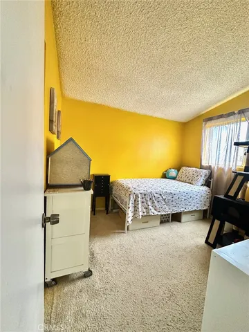 a bedroom with a bed and lamp next to a window