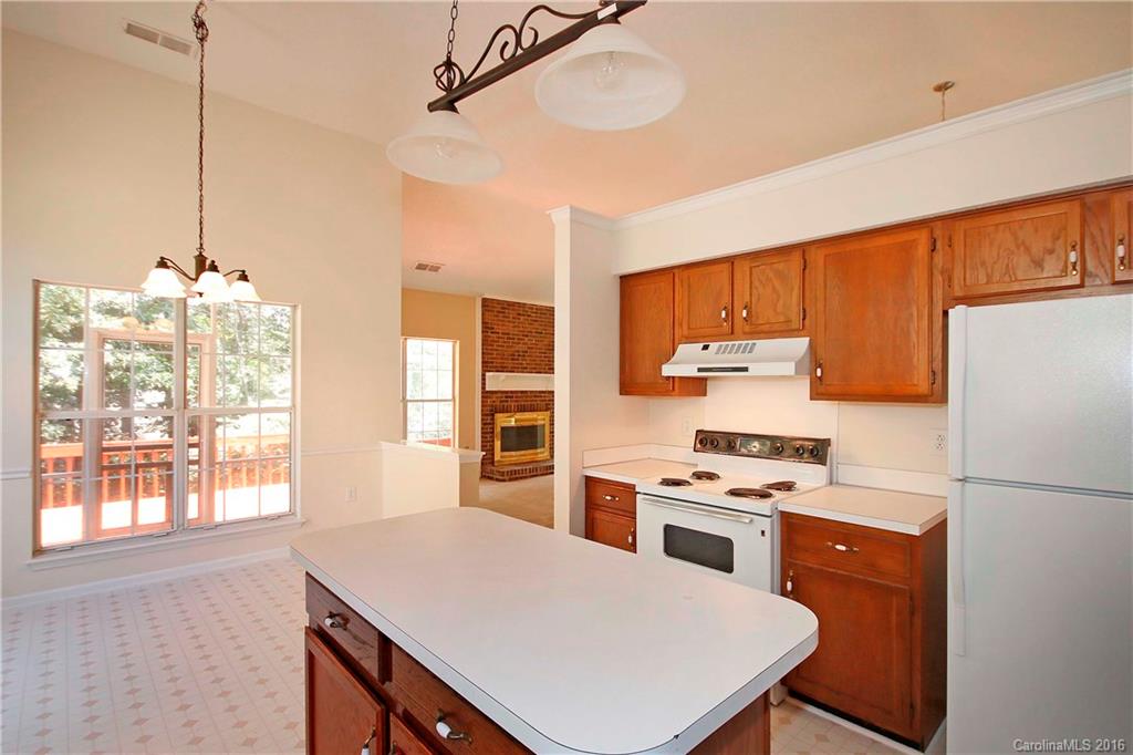 11931 Harris Ridge Drive Charlotte, NC 28269 - Photo 7 of 19 a kitchen with a refrigerator a stove a sink dishwasher with a dining table and chairs